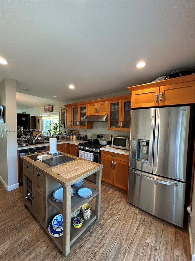 12680 SW 144th Ter, Miami, FL 33186 - kitchen featuring stainless steel appliances, range hood, recessed lighting, wood finished floors, and glass insert cabinets