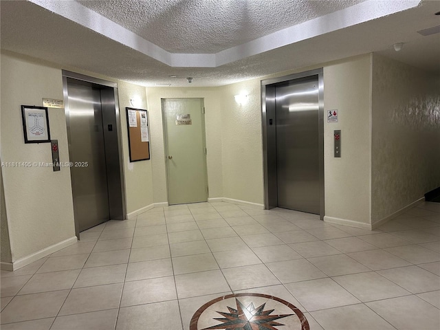 1100 NW Saint Charles Pl Unit 411, Pembroke Pines, FL 33026 - corridor with elevator, a textured ceiling, light tile patterned flooring, a textured wall, and baseboards