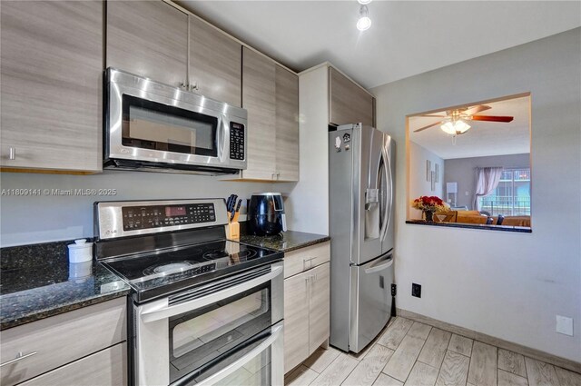 1775 N Andrews Sq Unit 104W, Fort Lauderdale, FL 33311 - kitchen with appliances with stainless steel finishes, a ceiling fan, dark stone counters, and light wood-style floors