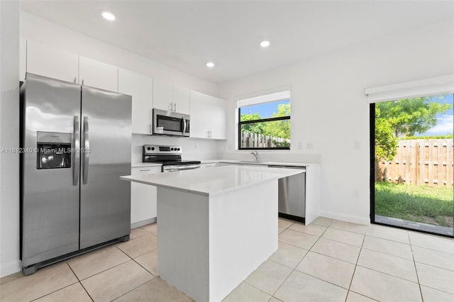 28581 SW 132nd Ct, Homestead, FL 33033 - kitchen featuring appliances with stainless steel finishes, a center island, light countertops, white cabinetry, and light tile patterned floors