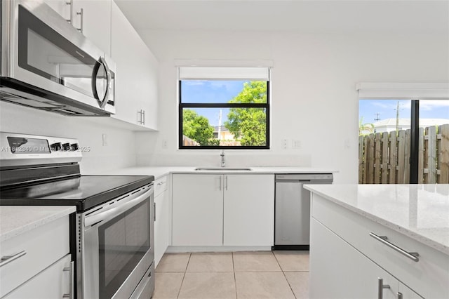 28581 SW 132nd Ct, Homestead, FL 33033 - kitchen featuring stainless steel appliances, a sink, light tile patterned flooring, and white cabinetry