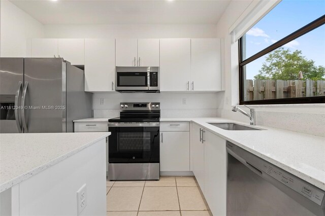 28569 SW 132nd Ct, Homestead, FL 33033 - kitchen with appliances with stainless steel finishes, a sink, white cabinetry, light tile patterned floors, and light stone countertops