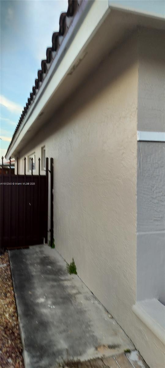 3149 W 68th Pl, Hialeah, FL 33018 - view of side of home with stucco siding and a tiled roof
