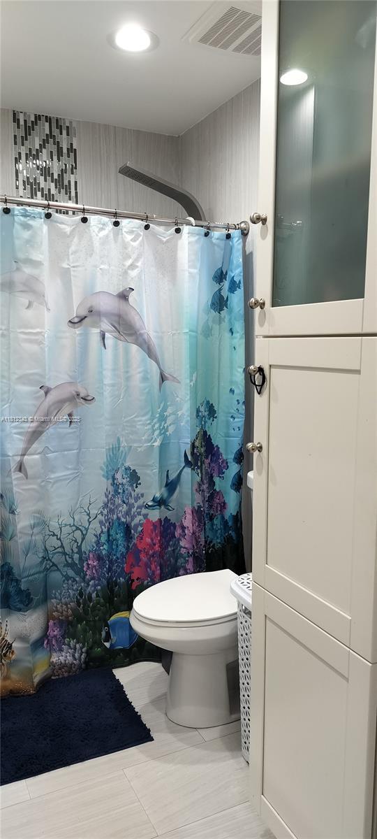3149 W 68th Pl, Hialeah, FL 33018 - bathroom with toilet and a shower with curtain