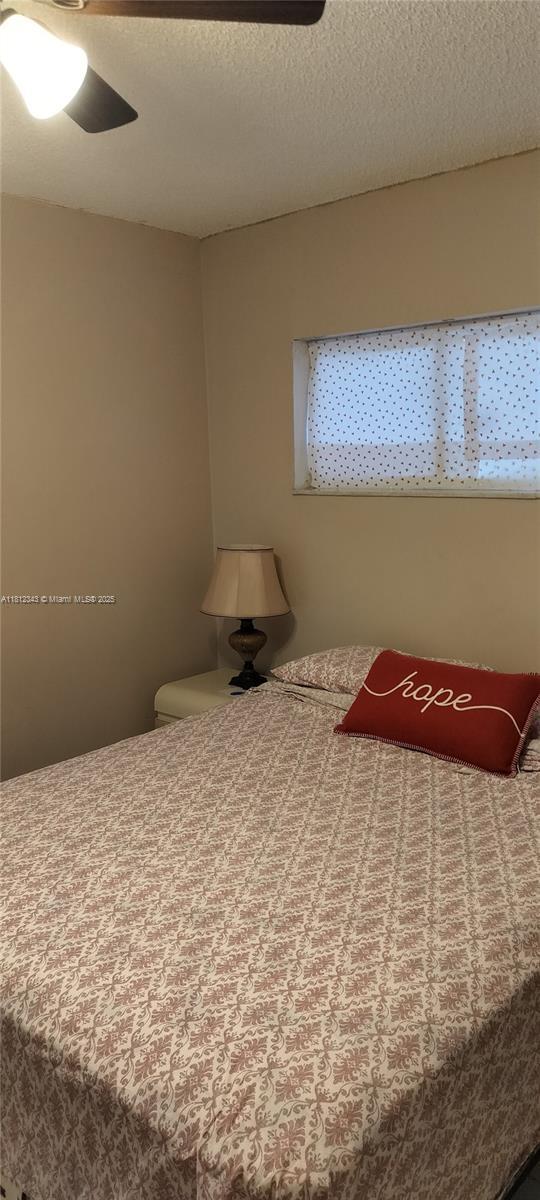3149 W 68th Pl, Hialeah, FL 33018 - bedroom featuring ceiling fan and a textured ceiling