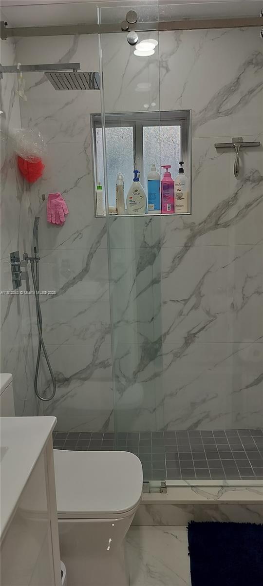 3149 W 68th Pl, Hialeah, FL 33018 - bathroom with toilet, marble look tile flooring, a marble finish shower, and vanity
