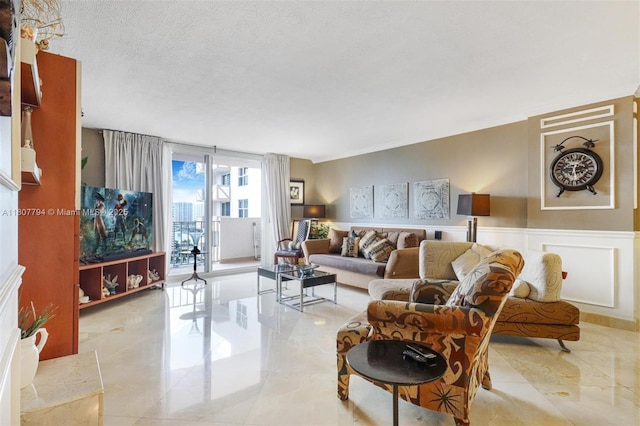 1865 S Ocean Dr Unit 18G, Hallandale Beach, FL 33009 - living room featuring a wainscoted wall and a textured ceiling