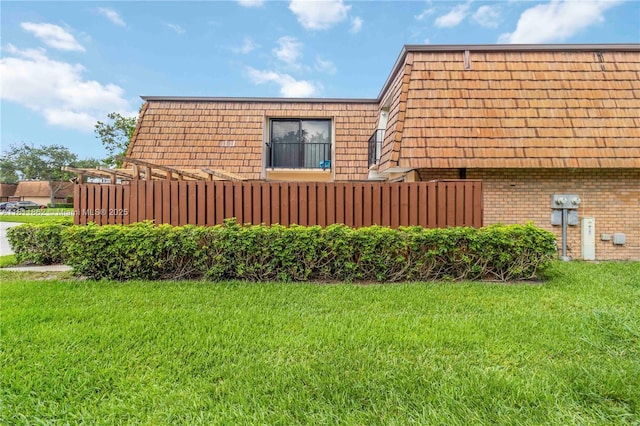 3003 30th Ln, Green Acres, FL 33463 - view of side of property featuring brick siding, mansard roof, and a yard