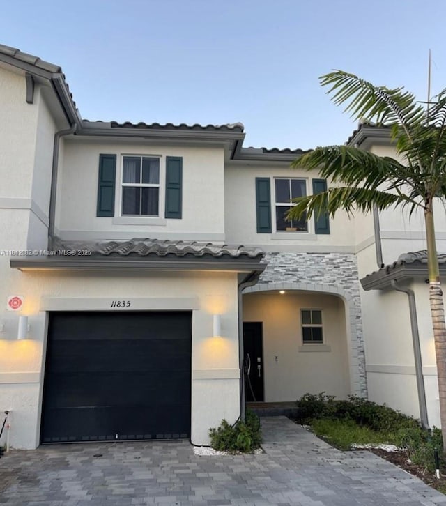 11835 NW 46th St, Coral Springs, FL 33076 - view of property with an attached garage, stucco siding, stone siding, and a tile roof