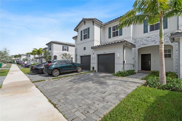 11835 NW 46th St, Coral Springs, FL 33076 - view of property featuring a garage, decorative driveway, stucco siding, stone siding, and a tile roof