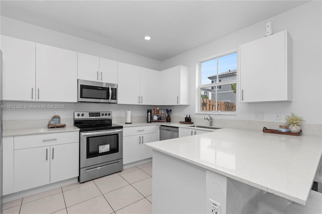 11835 NW 46th St, Coral Springs, FL 33076 - kitchen with appliances with stainless steel finishes, a peninsula, a sink, white cabinets, and recessed lighting