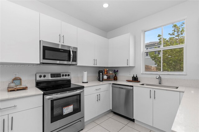 11835 NW 46th St, Coral Springs, FL 33076 - kitchen featuring appliances with stainless steel finishes, a sink, white cabinets, light tile patterned flooring, and recessed lighting