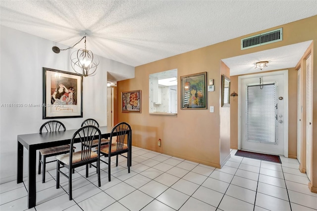 7355 NW 18th St Unit 106, Margate, FL 33063 - dining area with a chandelier, a textured ceiling, baseboards, and light tile patterned flooring