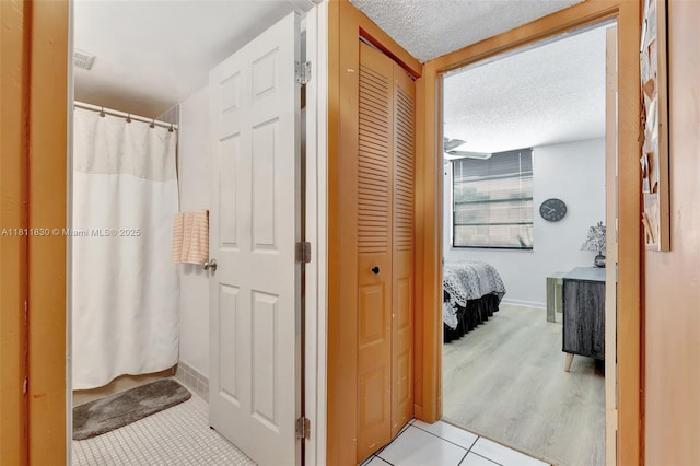 7355 NW 18th St Unit 106, Margate, FL 33063 - bathroom featuring a closet, baseboards, a textured ceiling, tile patterned floors, and a shower with shower curtain