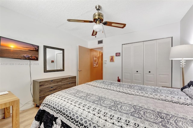 7355 NW 18th St Unit 106, Margate, FL 33063 - bedroom featuring light wood finished floors, a closet, a textured ceiling, and a ceiling fan