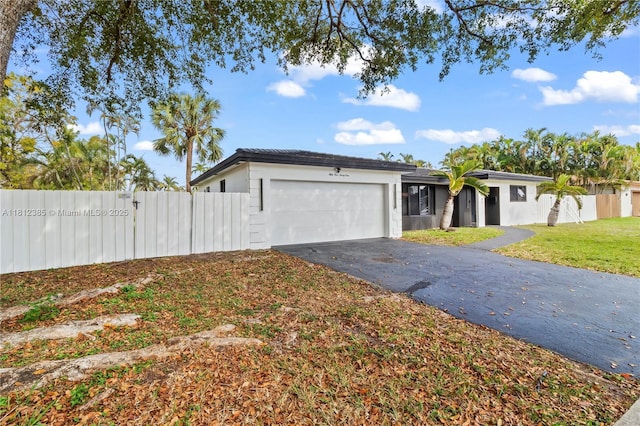 5131 Monroe St, Hollywood, FL 33021 - view of front facade with an attached garage, driveway, and a gate