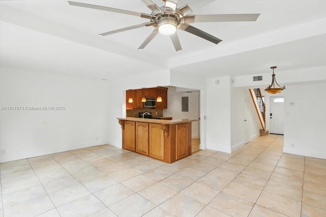 4225 N 76th Ave, Davie, FL 33024 - kitchen with stainless steel microwave, a peninsula, backsplash, light tile patterned floors, and electric panel