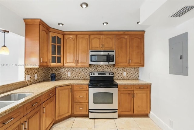 4225 N 76th Ave, Davie, FL 33024 - kitchen with stainless steel appliances, electric panel, brown cabinets, glass insert cabinets, and decorative backsplash