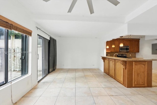 4225 N 76th Ave, Davie, FL 33024 - kitchen with stainless steel appliances, backsplash, a peninsula, ceiling fan, and brown cabinets