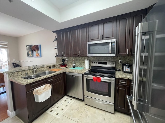 8980 W Flagler St Unit 202, Miami, FL 33174 - kitchen with appliances with stainless steel finishes, a sink, a peninsula, light stone counters, and dark brown cabinetry