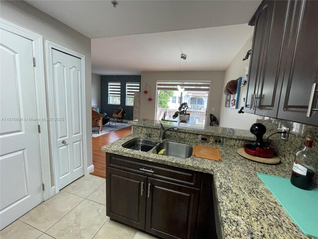 8980 W Flagler St Unit 202, Miami, FL 33174 - kitchen featuring a sink, a peninsula, light tile patterned floors, light stone countertops, and dark brown cabinets