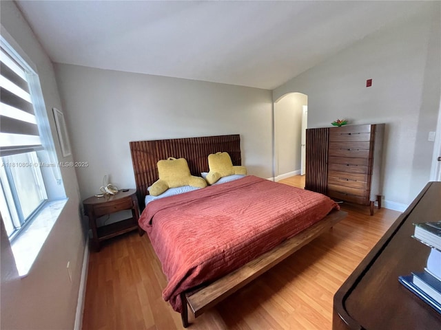 8980 W Flagler St Unit 202, Miami, FL 33174 - bedroom featuring light wood-style flooring, arched walkways, and baseboards