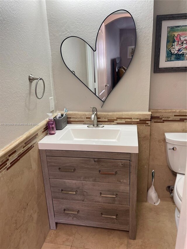 8980 W Flagler St Unit 202, Miami, FL 33174 - half bath featuring tile walls, toilet, vanity, a wainscoted wall, and tile patterned floors