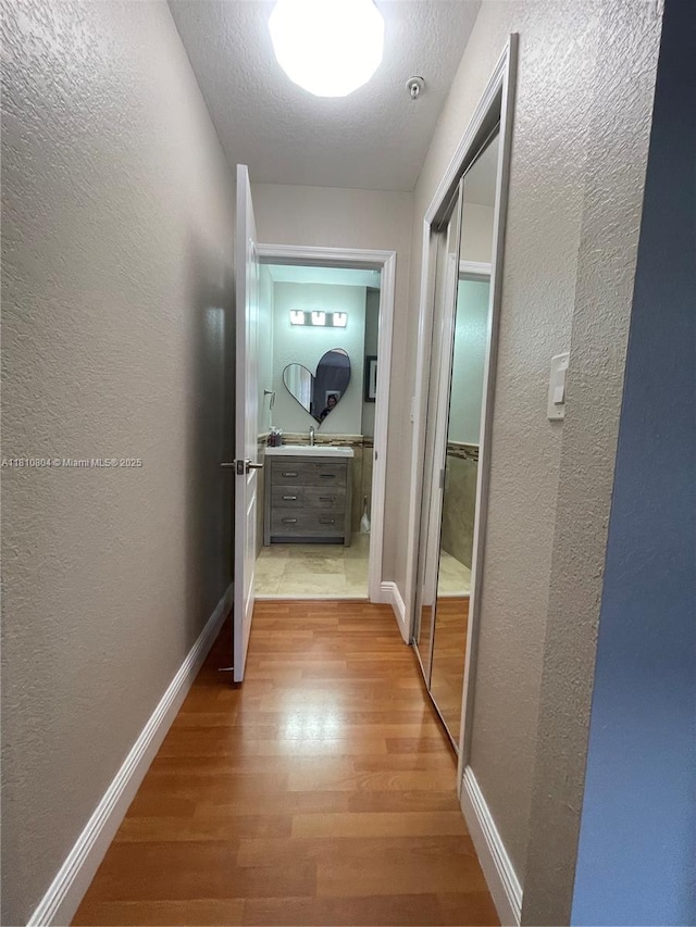 8980 W Flagler St Unit 202, Miami, FL 33174 - hall featuring wood finished floors, a textured wall, and baseboards