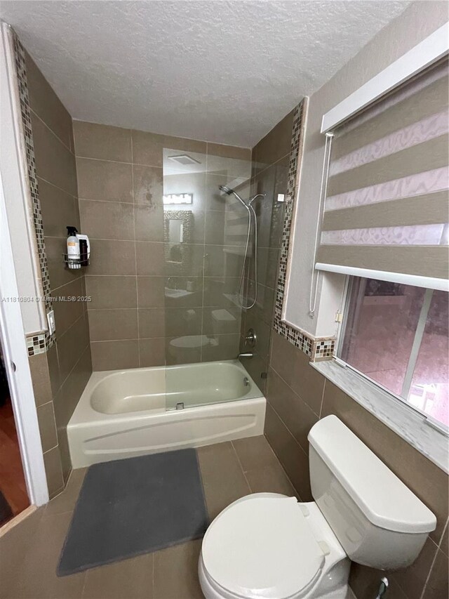 8980 W Flagler St Unit 202, Miami, FL 33174 - full bath featuring shower / bathtub combination, toilet, a textured ceiling, tile patterned flooring, and tile walls