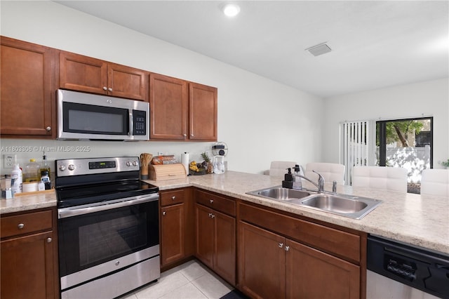 9214 W 33rd Ln, Hialeah, FL 33018 - kitchen with appliances with stainless steel finishes, a sink, light countertops, light tile patterned floors, and a peninsula
