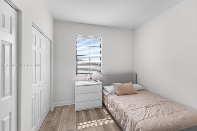 9214 W 33rd Ln, Hialeah, FL 33018 - bedroom featuring a closet, light wood-style floors, and baseboards
