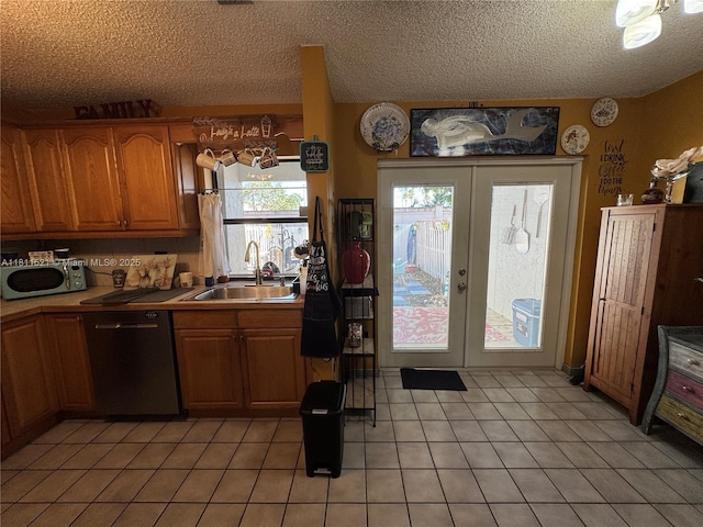 10428 NW 3rd St, Pembroke Pines, FL 33026 - kitchen with appliances with stainless steel finishes, french doors, brown cabinets, light tile patterned floors, and a textured ceiling