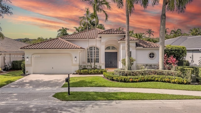 1220 Iris Ct, Weston, FL 33326 - mediterranean / spanish home with a tile roof, decorative driveway, stucco siding, and a garage
