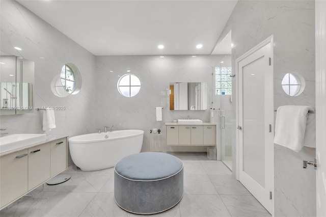 1220 Iris Ct, Weston, FL 33326 - bathroom with marble finish flooring, two vanities, a shower stall, a freestanding bath, and recessed lighting