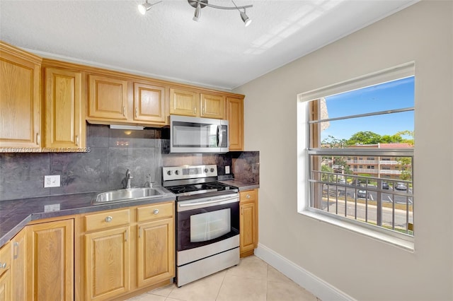 1055 Country Club Dr Unit 406, Margate, FL 33063 - kitchen featuring appliances with stainless steel finishes, a sink, light tile patterned flooring, backsplash, and dark countertops