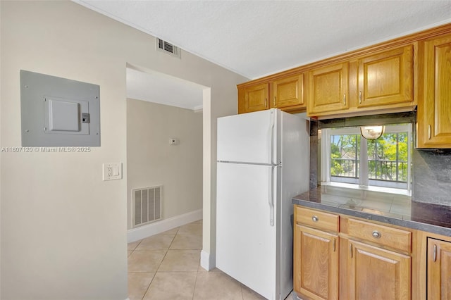 1055 Country Club Dr Unit 406, Margate, FL 33063 - kitchen featuring freestanding refrigerator, electric panel, dark countertops, light tile patterned floors, and decorative backsplash