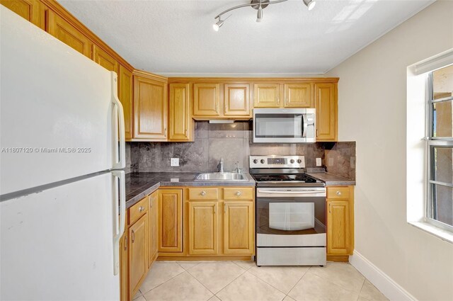 1055 Country Club Dr Unit 406, Margate, FL 33063 - kitchen with stainless steel appliances, a sink, backsplash, light tile patterned floors, and healthy amount of natural light