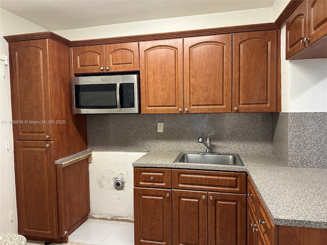 1130 11th St Unit 4J, Miami Beach, FL 33139 - kitchen with stainless steel microwave, a sink, decorative backsplash, and brown cabinets