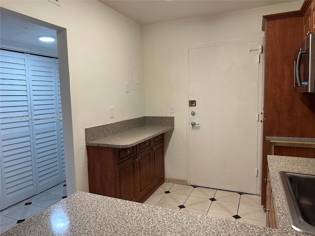 1130 11th St Unit 4J, Miami Beach, FL 33139 - kitchen with stainless steel microwave, light tile patterned flooring, a sink, and dark countertops