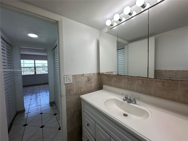 1130 11th St Unit 4J, Miami Beach, FL 33139 - bathroom featuring tile patterned flooring, vanity, tile walls, and wainscoting