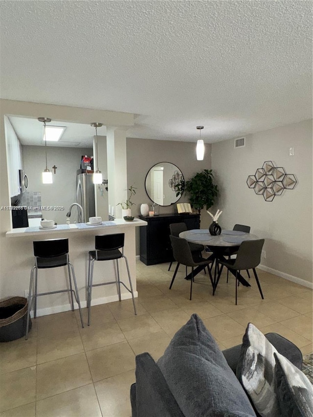3586 N University Dr Unit U-6, Coral Springs, FL 33065 - living area featuring light tile patterned flooring, a textured ceiling, and baseboards