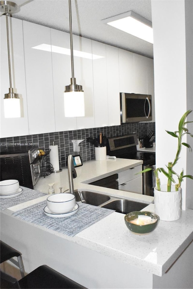 3586 N University Dr Unit U-6, Coral Springs, FL 33065 - kitchen with stainless steel appliances, backsplash, white cabinets, light stone counters, and modern cabinets