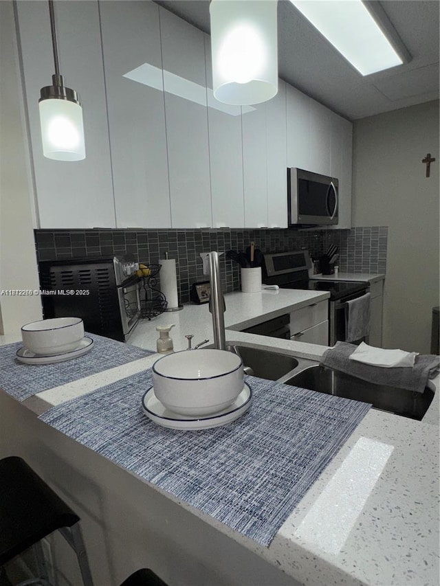 3586 N University Dr Unit U-6, Coral Springs, FL 33065 - kitchen with appliances with stainless steel finishes, tasteful backsplash, white cabinetry, pendant lighting, and modern cabinets