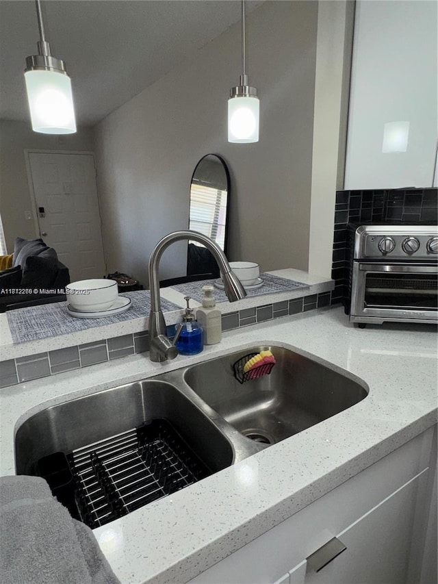 3586 N University Dr Unit U-6, Coral Springs, FL 33065 - kitchen view of a sink, light stone counters, tasteful backsplash, and decorative light fixtures