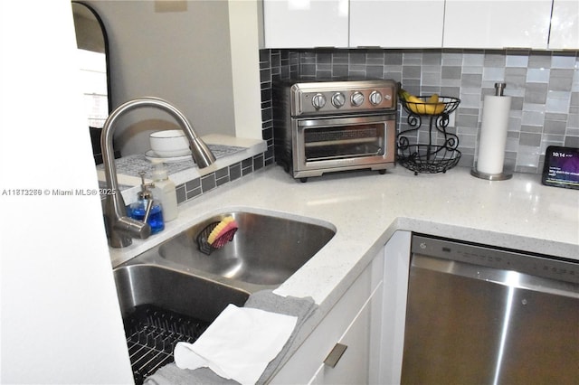 3586 N University Dr Unit U-6, Coral Springs, FL 33065 - kitchen view of dishwasher, a sink, white cabinets, and backsplash