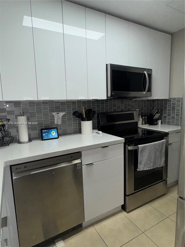 3586 N University Dr Unit U-6, Coral Springs, FL 33065 - kitchen featuring appliances with stainless steel finishes, light countertops, white cabinetry, and decorative backsplash