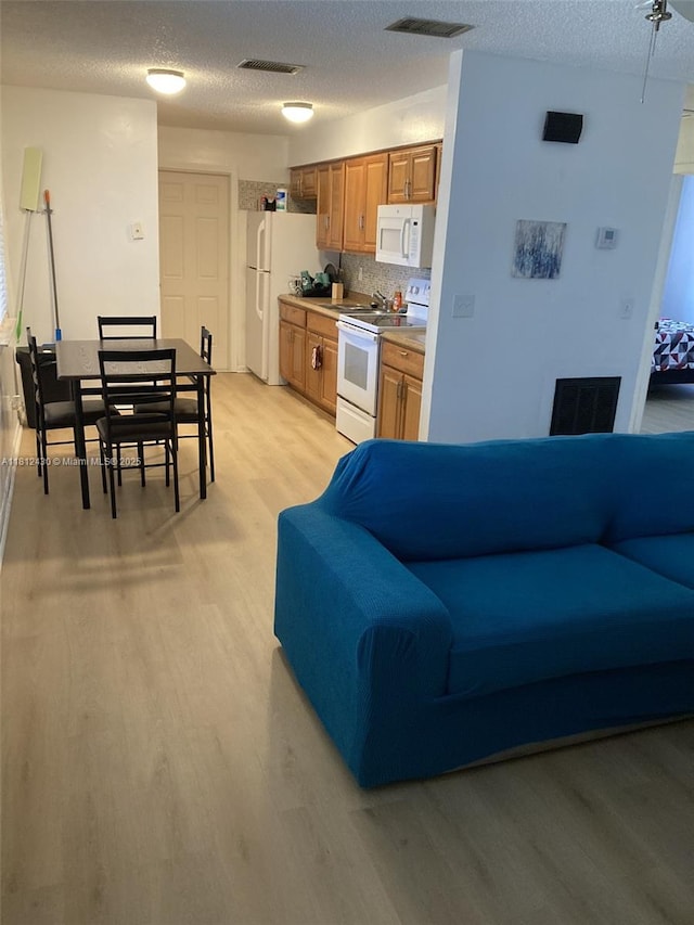 6132 SW 39th St, Miramar, FL 33023 - living area with light wood-style flooring and a textured ceiling