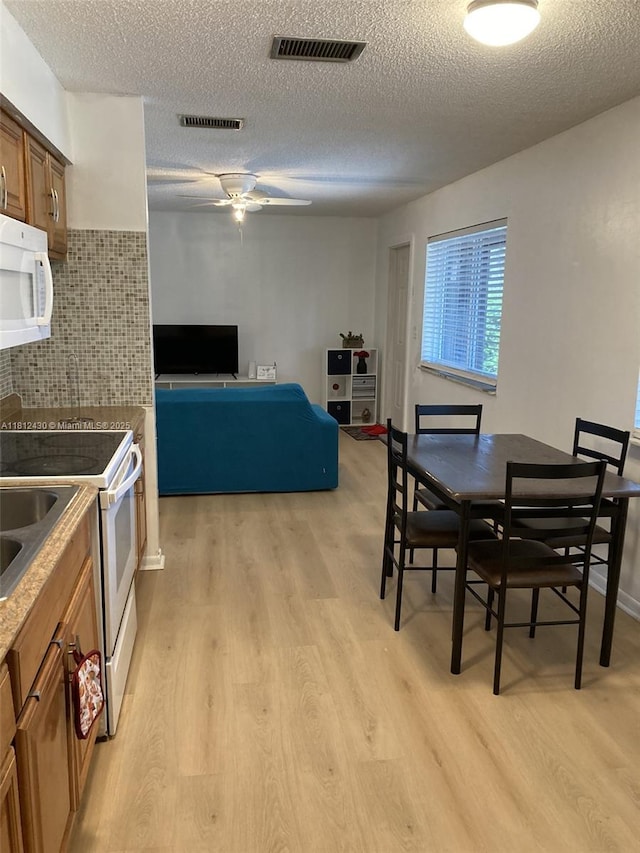 6132 SW 39th St, Miramar, FL 33023 - dining area featuring light wood-type flooring, a textured ceiling, and a ceiling fan