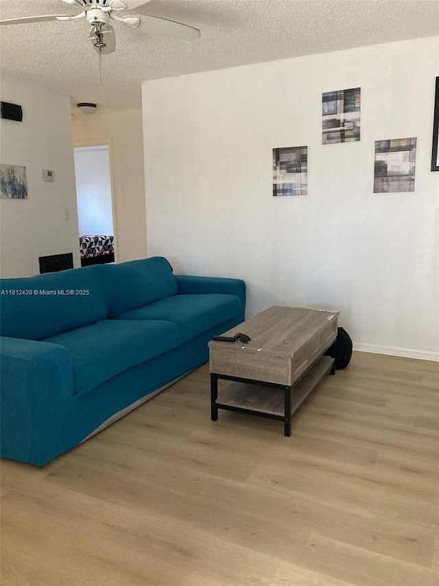 6132 SW 39th St, Miramar, FL 33023 - living area featuring light wood-style flooring, ceiling fan, a textured ceiling, and baseboards