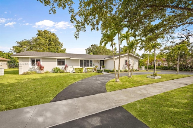 17243 SW 87th Ave, Palmetto Bay, FL 33157 - view of front facade with asphalt driveway, a front yard, and stucco siding